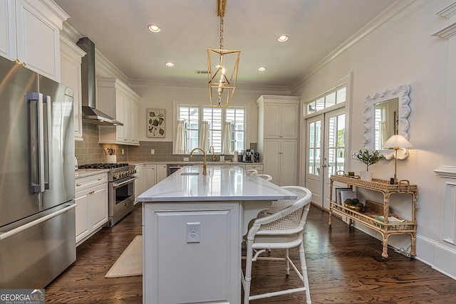 kitchen with a kitchen island, dark hardwood / wood-style flooring, wall chimney exhaust hood, pendant lighting, and high end appliances