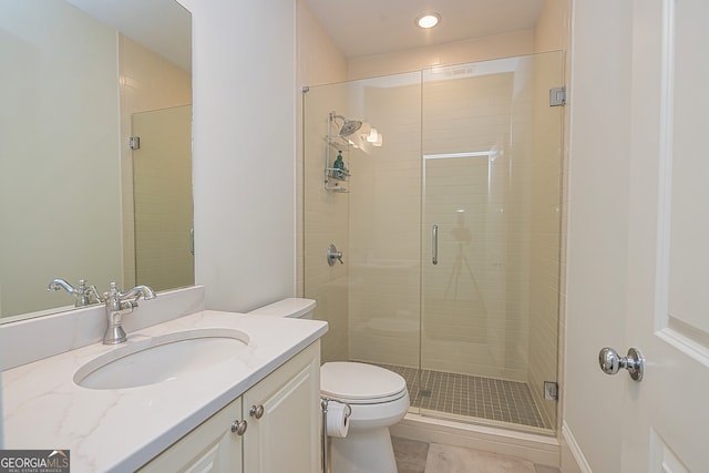 bathroom featuring vanity, a shower with shower door, toilet, and tile patterned flooring