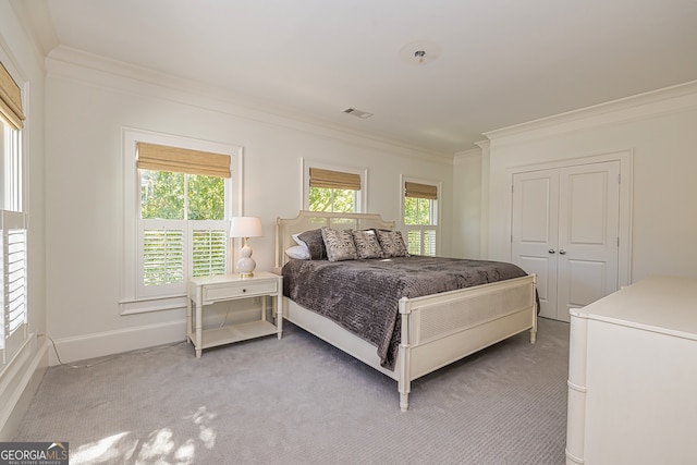 carpeted bedroom featuring a closet, ornamental molding, and multiple windows