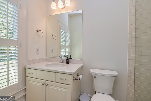 bathroom featuring vanity, toilet, and a healthy amount of sunlight