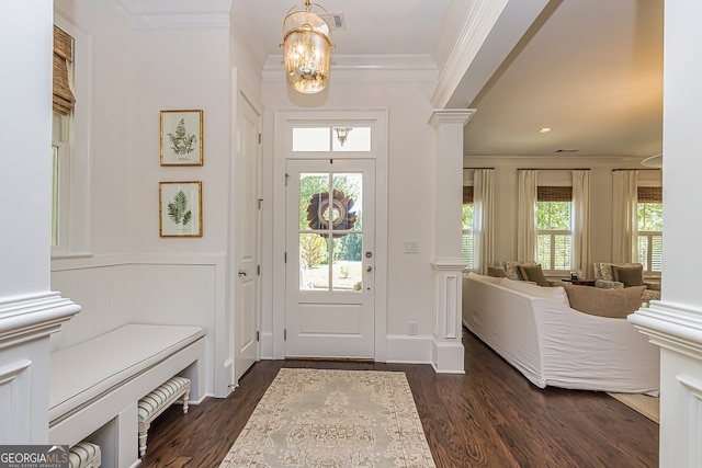 foyer entrance with ornamental molding, a chandelier, and dark hardwood / wood-style flooring