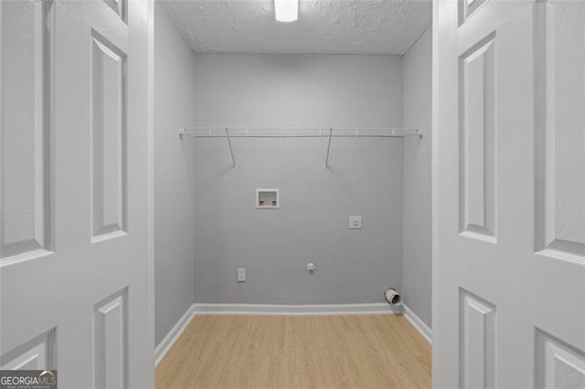 laundry area featuring hookup for a gas dryer, hookup for a washing machine, electric dryer hookup, and light hardwood / wood-style floors