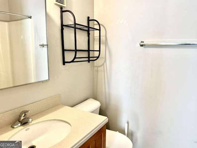 bathroom featuring vanity, toilet, and walk in shower