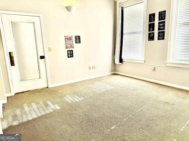 carpeted spare room featuring plenty of natural light