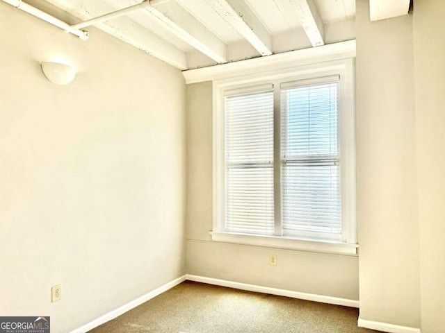 spare room with carpet and vaulted ceiling with beams