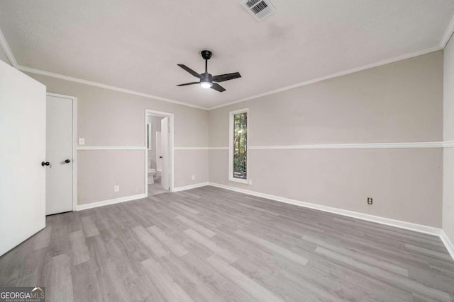 empty room with crown molding and light wood-type flooring