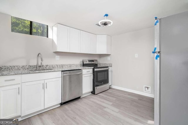 kitchen featuring sink, appliances with stainless steel finishes, light hardwood / wood-style flooring, and white cabinets