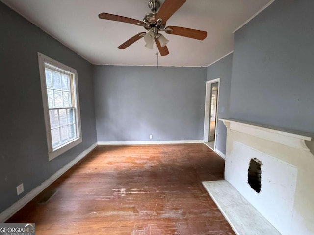 unfurnished living room featuring dark wood-type flooring and ceiling fan