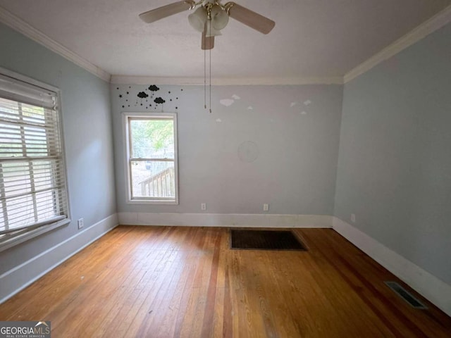 empty room with ornamental molding, hardwood / wood-style flooring, ceiling fan, and a wealth of natural light