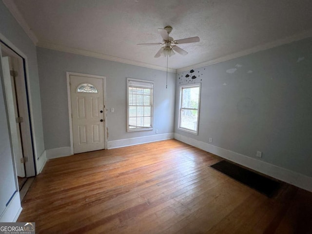 foyer entrance featuring crown molding, light hardwood / wood-style flooring, and ceiling fan