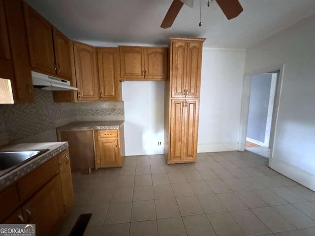 kitchen with ceiling fan, tasteful backsplash, sink, and light tile patterned floors