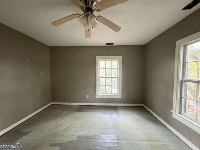 empty room featuring ceiling fan, a healthy amount of sunlight, a textured ceiling, and light wood-type flooring