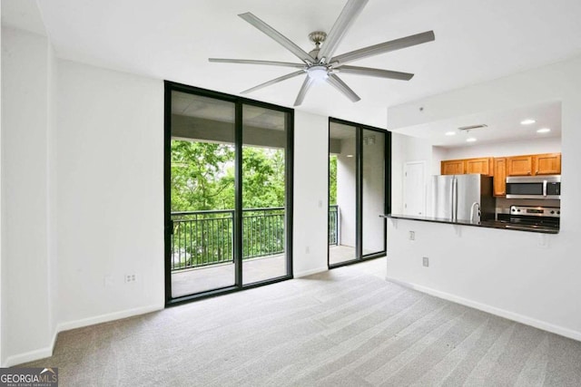 unfurnished living room with ceiling fan and light colored carpet