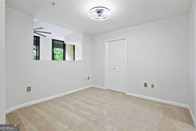 empty room with ceiling fan and light colored carpet