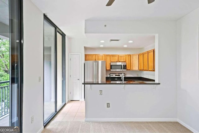 kitchen featuring light carpet, kitchen peninsula, stainless steel appliances, and ceiling fan