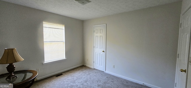 interior space featuring a textured ceiling and carpet floors