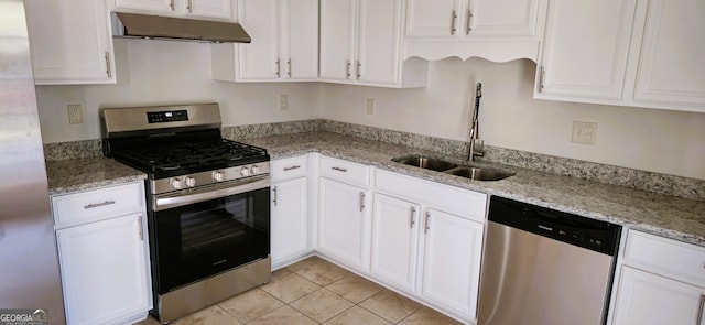 kitchen featuring white cabinets, light stone countertops, stainless steel appliances, and sink