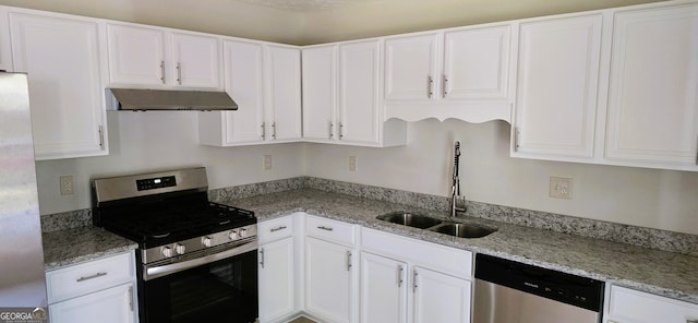 kitchen featuring appliances with stainless steel finishes, white cabinets, light stone countertops, and sink