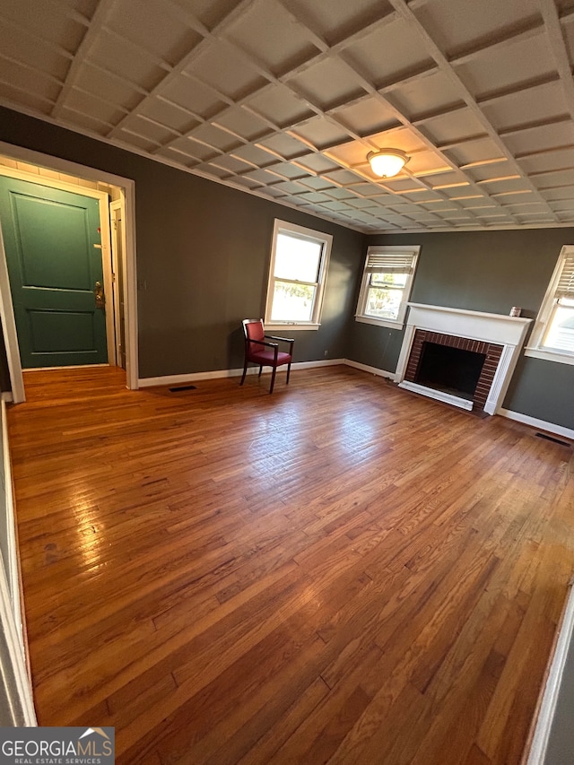 unfurnished living room with coffered ceiling, a fireplace, and hardwood / wood-style flooring