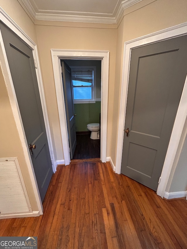 hallway with ornamental molding and dark hardwood / wood-style floors