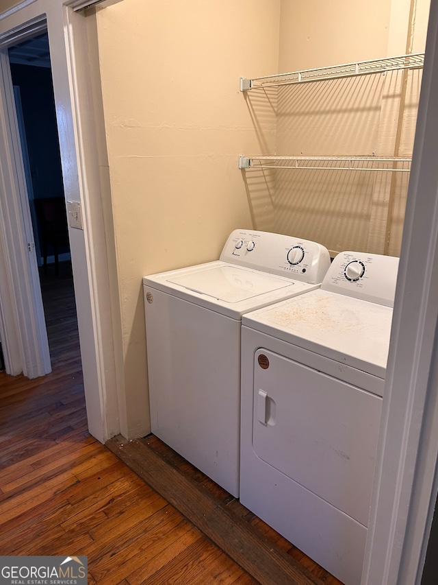 laundry room featuring dark hardwood / wood-style floors and washer and clothes dryer