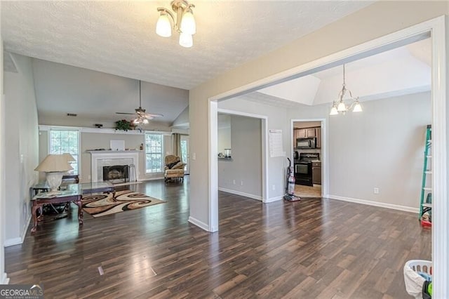 living room with dark wood-type flooring, a textured ceiling, lofted ceiling, and ceiling fan with notable chandelier