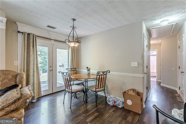 dining room with french doors, dark hardwood / wood-style floors, and a textured ceiling