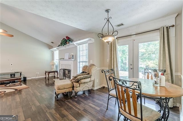 dining room with lofted ceiling, a textured ceiling, french doors, and dark hardwood / wood-style flooring