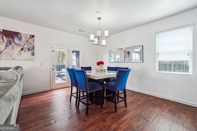 dining area with a chandelier and dark hardwood / wood-style flooring