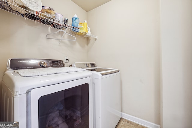 laundry room with independent washer and dryer and light tile patterned floors