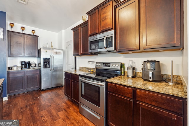 kitchen featuring light stone countertops, stainless steel appliances, and dark hardwood / wood-style flooring