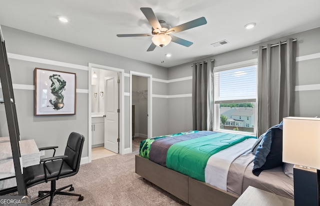 bedroom with a spacious closet, ensuite bath, a closet, ceiling fan, and light colored carpet