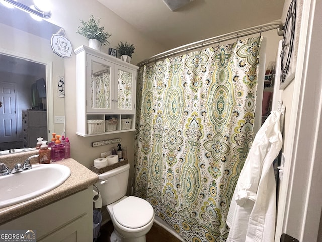 bathroom with toilet, curtained shower, and vanity