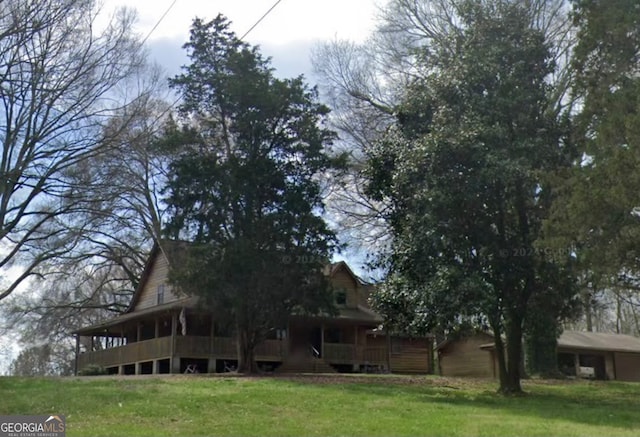 rear view of house featuring a yard and a wooden deck