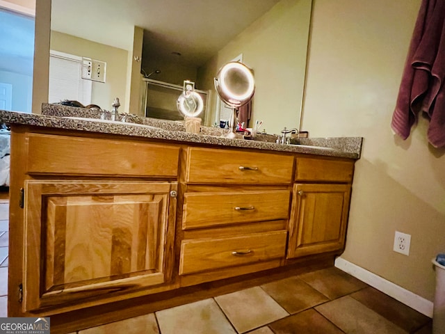 bathroom featuring a shower with door, vanity, and tile patterned floors