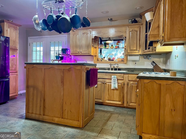 kitchen featuring french doors, black fridge, sink, tasteful backsplash, and pendant lighting