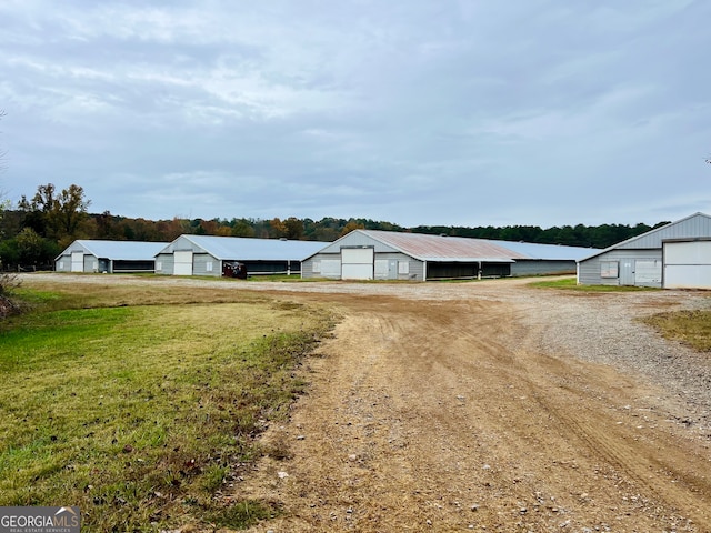 view of front of house featuring an outdoor structure and a front lawn