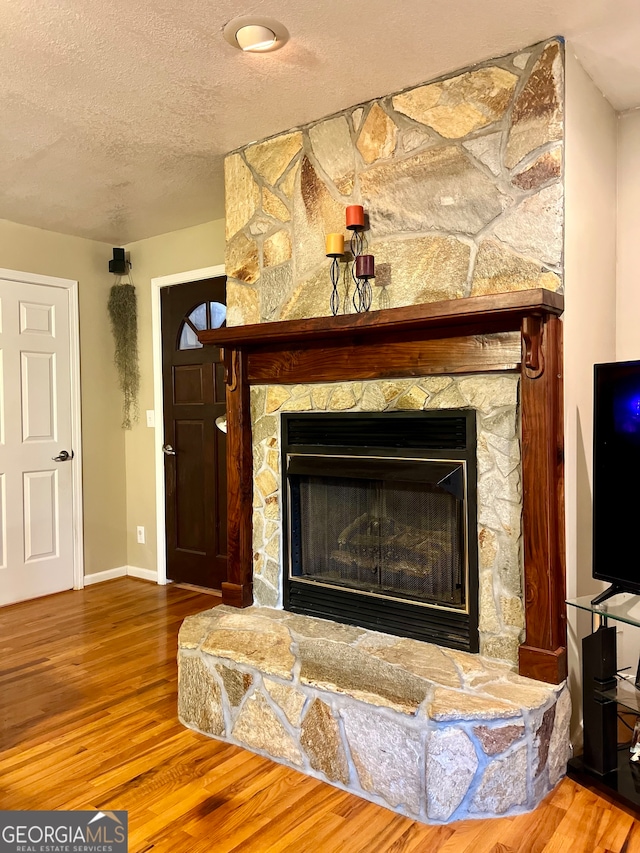 room details featuring a textured ceiling, a fireplace, and hardwood / wood-style flooring