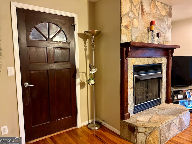 foyer entrance featuring a fireplace and hardwood / wood-style flooring