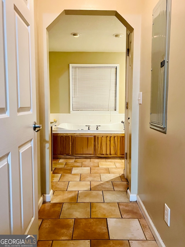 bathroom with electric panel and a bath