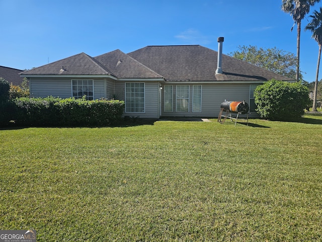 rear view of property with a lawn