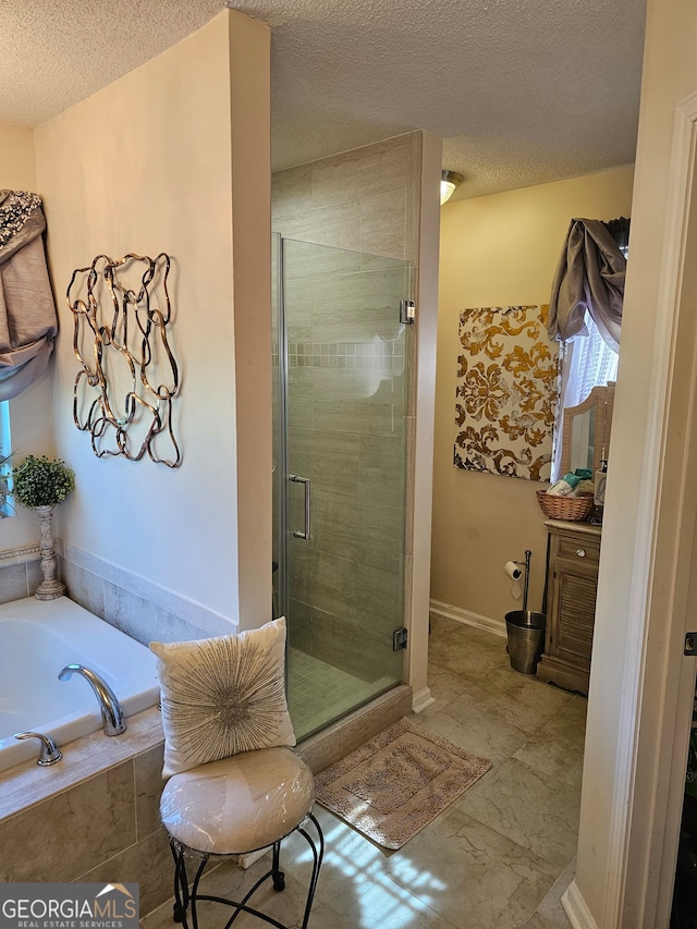 bathroom with vanity, a textured ceiling, and separate shower and tub