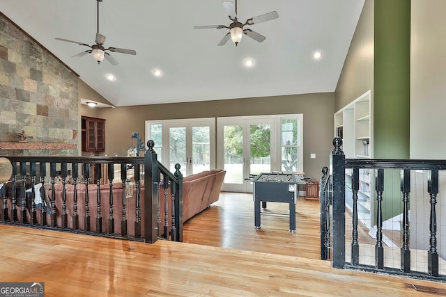 game room featuring french doors, light hardwood / wood-style floors, ceiling fan, and high vaulted ceiling