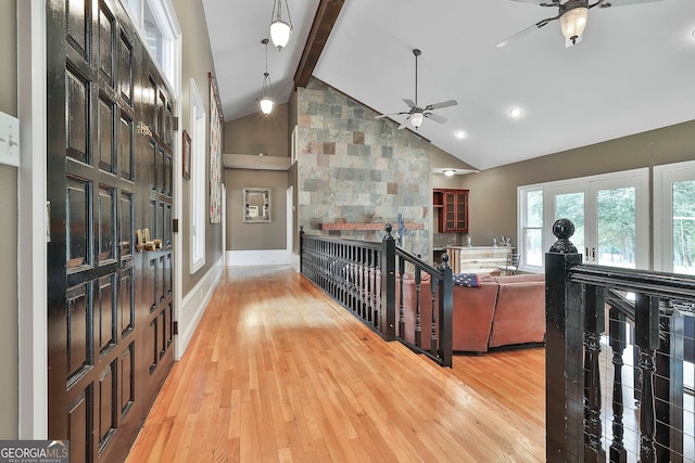 interior space featuring light wood-type flooring, ceiling fan, high vaulted ceiling, and beam ceiling