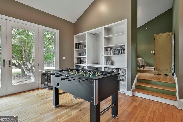 playroom featuring high vaulted ceiling, plenty of natural light, and light hardwood / wood-style floors