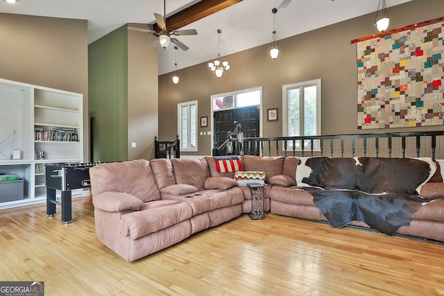 living room featuring high vaulted ceiling, light hardwood / wood-style flooring, and ceiling fan with notable chandelier