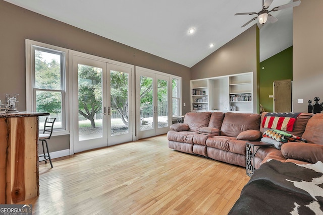 living room featuring high vaulted ceiling, french doors, ceiling fan, and light hardwood / wood-style flooring