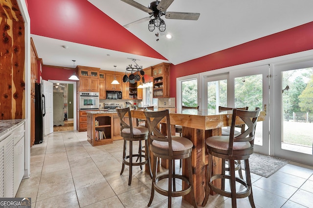 dining room with vaulted ceiling, light tile patterned floors, and ceiling fan