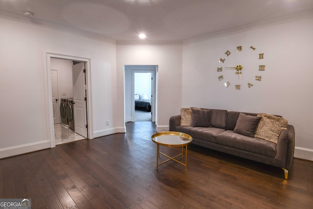 living room with crown molding, washing machine and clothes dryer, and dark hardwood / wood-style flooring