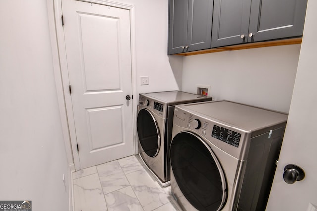 washroom featuring cabinets and washer and clothes dryer